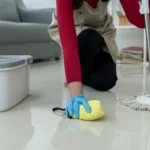 Pessoa passando mop de microfibra em chão claro para ensinar como limpar porcelanato fosco sem deixar manchas.