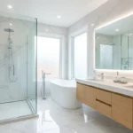 Banheiro moderno e muito limpo com mármore branco, chuveiro de vidro, banheira e bancada dupla, limpeza de banheiros em Salvador